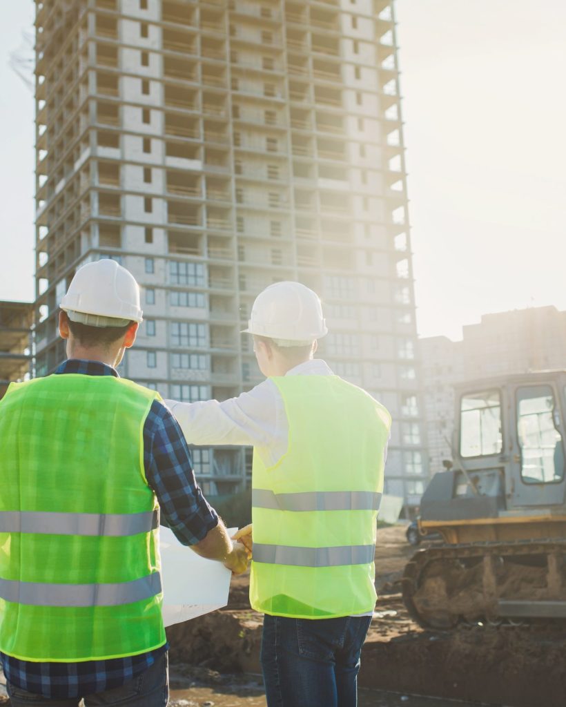 Two young man architects or engineers on a building construction site